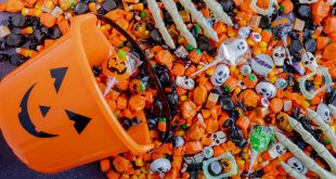 Orange pumpkin pail spilling Halloween candy