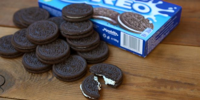 Many OREO sandwich cookies with pack on wooden background