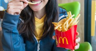 Woman holding and eating McDonalds fries