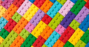 Many toy blocks in different colors making up one large square shape